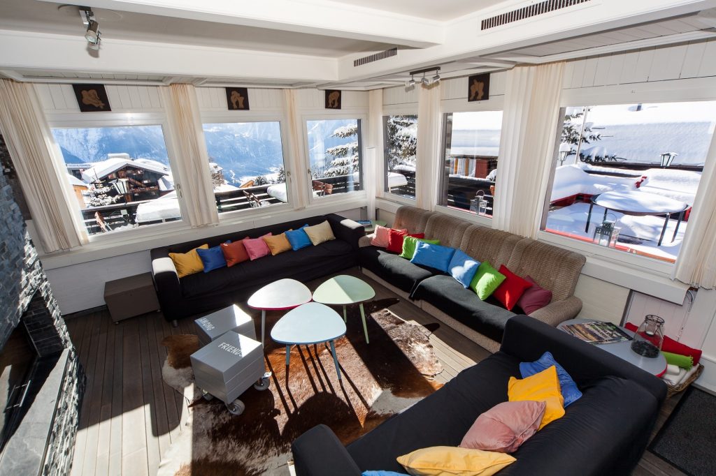 Ein Wohnzimmer mit Sofas und Blick auf die schneebedeckten Berge.